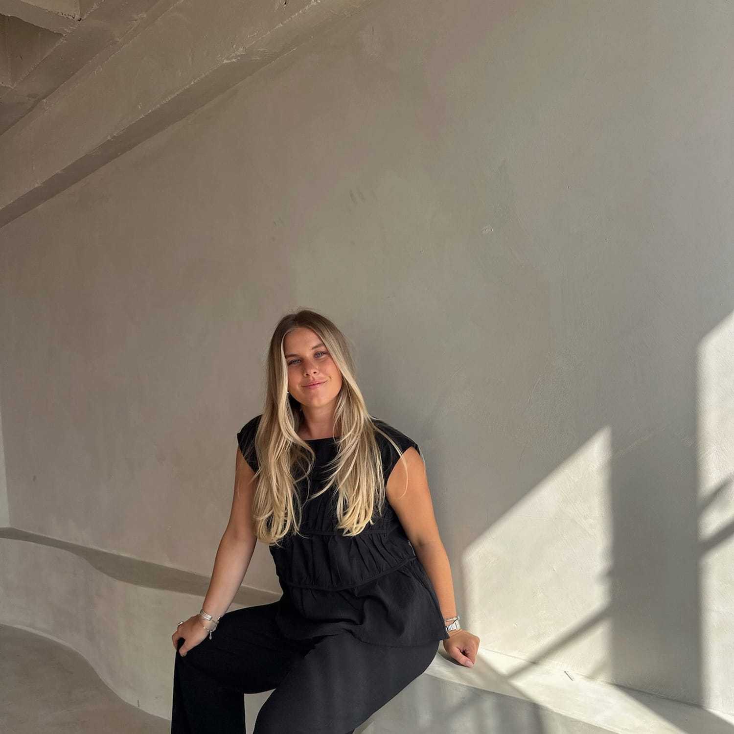 Portrait of Ally Nelson, a professional stylist at Stranded Salon, showcasing their expertise and style.