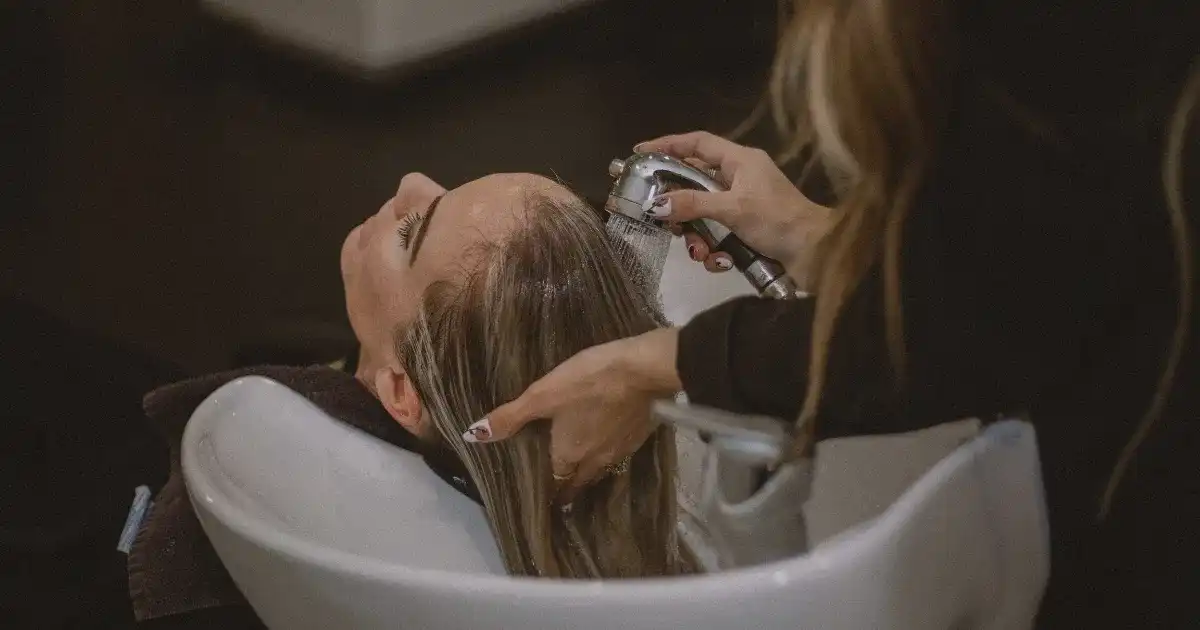 Person getting hair washed at a salon sink.
