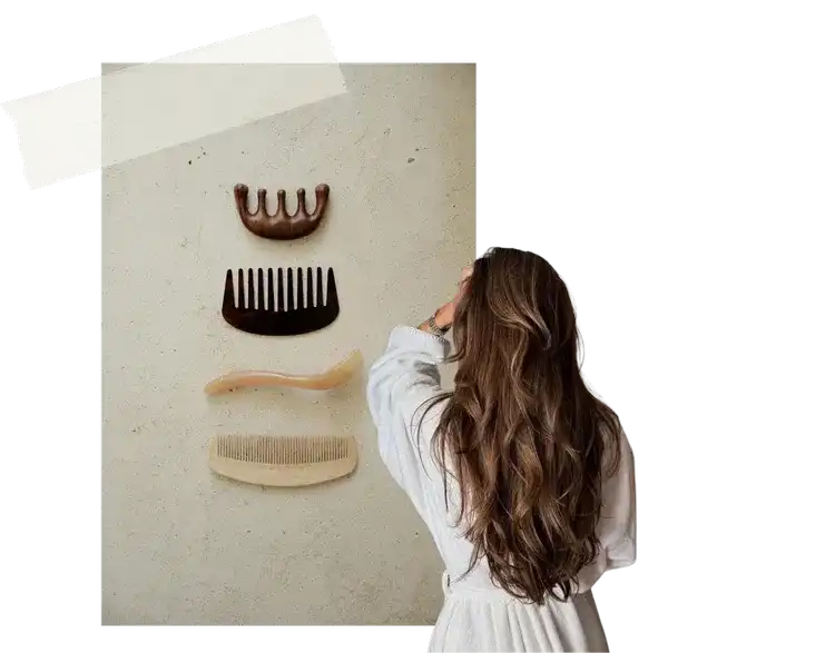 Woman viewing a display of vintage combs on a wall.